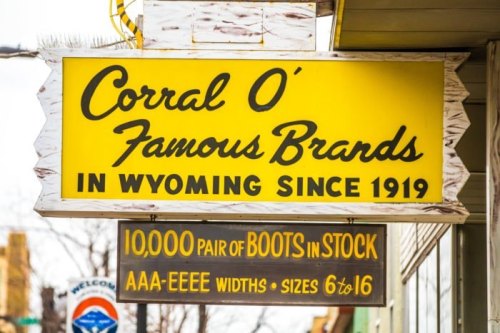 Sign for Corral O' Famous Brands in Wyoming, established in 1919, advertising 10,000 pairs of boots in stock.