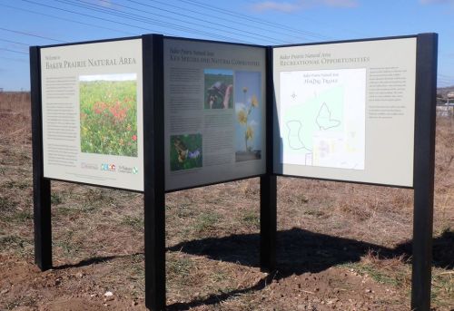 Two informational signs about Baker Prairie Natural Area, detailing its ecology and recreational opportunities.