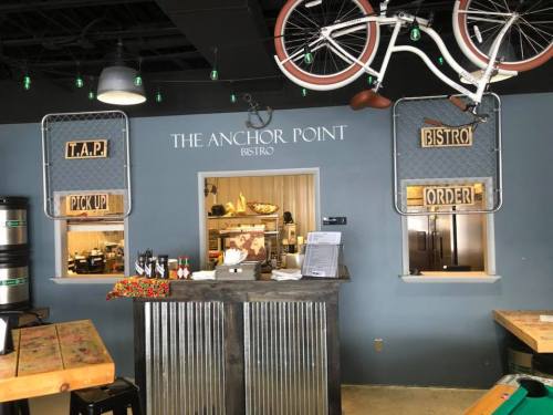 Interior of The Anchor Point Bistro featuring a counter with "Pick Up" and "Order" signs, and a bicycle hanging above.