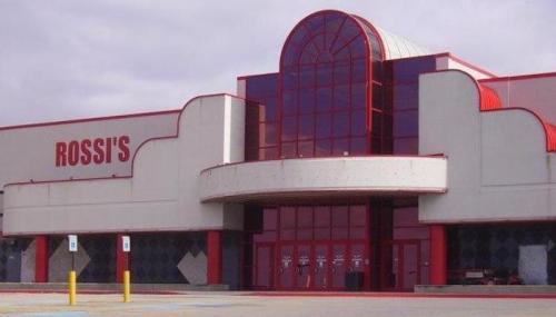 Exterior of Rossi's store featuring a large red and gray facade with an arched entrance and multiple doors.