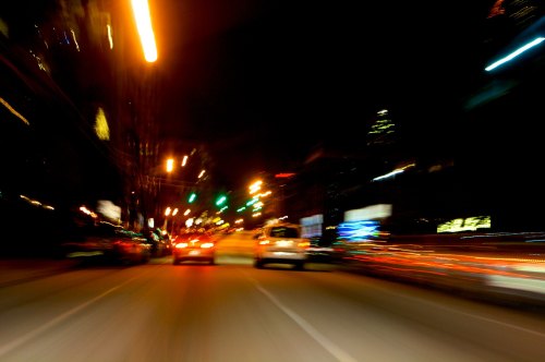 A blurred night scene of city traffic with colorful lights and streaks, suggesting high speed and movement.