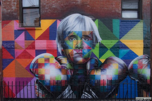 Colorful mural featuring a portrait of a person with white hair, wearing boxing gloves, set against a geometric background.