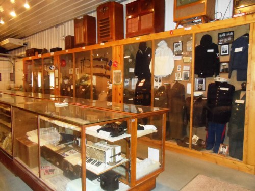Display of historical artifacts, including uniforms, photographs, and vintage items in a museum setting.
