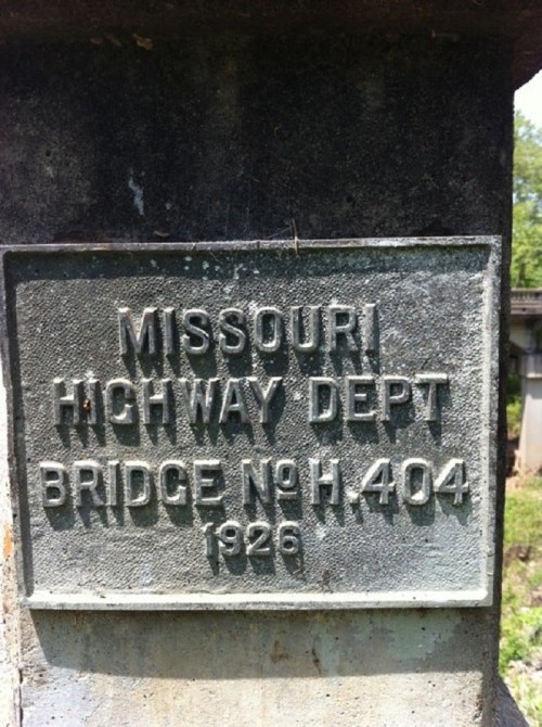 Metal plaque on a bridge, reading "Missouri Highway Dept, Bridge No. H.404, 1926."
