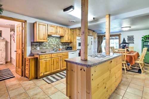 Cozy kitchen with wooden cabinets, a central island, and a dining area featuring a round table and chairs.