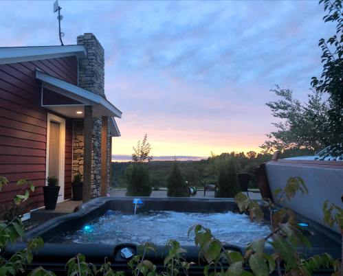 A hot tub on a patio with a scenic view of a sunset and trees in the background.
