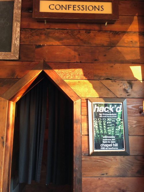 A wooden entrance labeled "CONFESSIONS" with a poster for an event titled "hack'd" nearby.