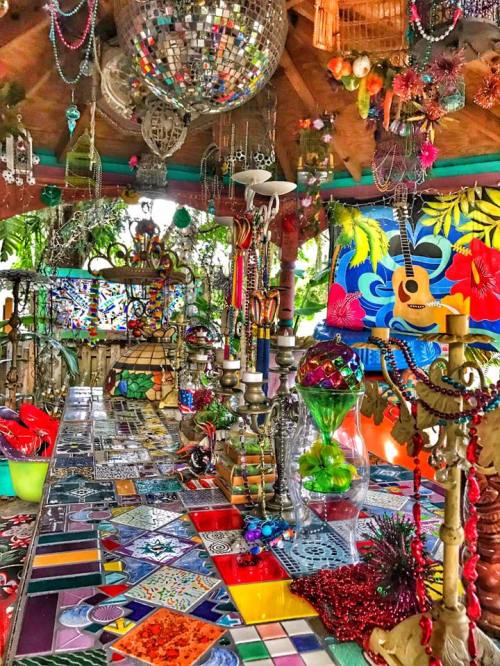A vibrant, colorful interior filled with decorative tiles, disco balls, and eclectic ornaments.