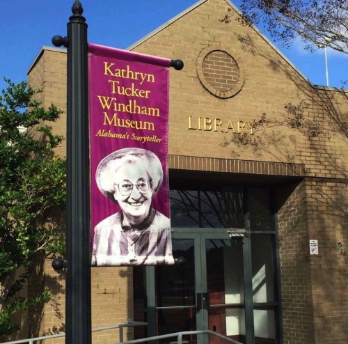 Banner for the Kathryn Tucker Windham Museum, featuring a smiling woman, outside a library building.