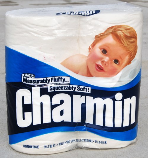 A roll of Charmin toilet paper featuring a smiling baby on the packaging, labeled "Measurably Fluffy... Squeezably Soft!"