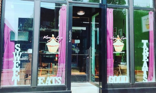 A storefront with large windows displaying "Sweet Eats" and "Good Treats" alongside a cupcake graphic.