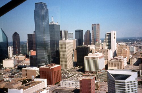 Aerial view of a city skyline featuring tall buildings and clear blue skies.