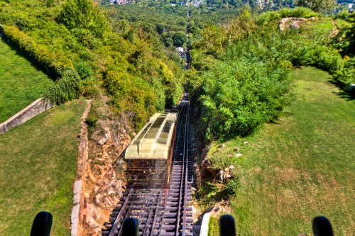 Aerial view of a funicular railway descending through a lush green landscape.