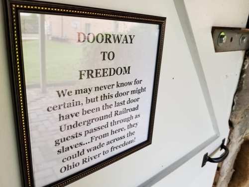 Sign on a doorframe reading "Doorway to Freedom," referencing the Underground Railroad and its historical significance.