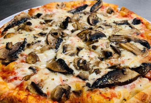 A close-up of a pizza topped with melted cheese and a generous layer of sliced mushrooms on a golden crust.