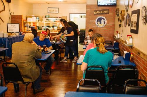 A cozy diner scene with patrons at tables, a server taking orders, and a warm, inviting atmosphere.