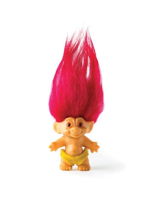 A colorful troll doll with bright red hair and a cheerful expression, wearing a yellow skirt.
