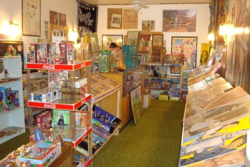 A colorful vintage shop filled with collectibles, toys, and memorabilia displayed on shelves and tables.