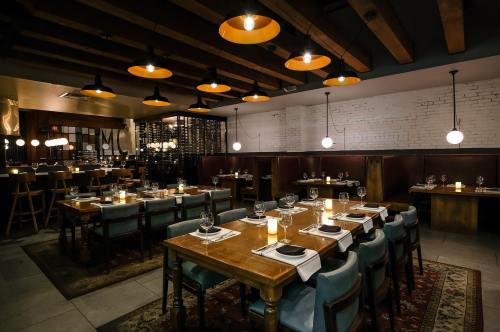 Cozy restaurant interior with wooden beams, warm lighting, and elegantly set tables.