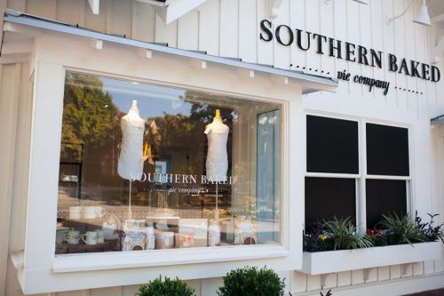 A storefront with a sign reading "Southern Baked Pie Company," featuring display mannequins and baked goods in the window.