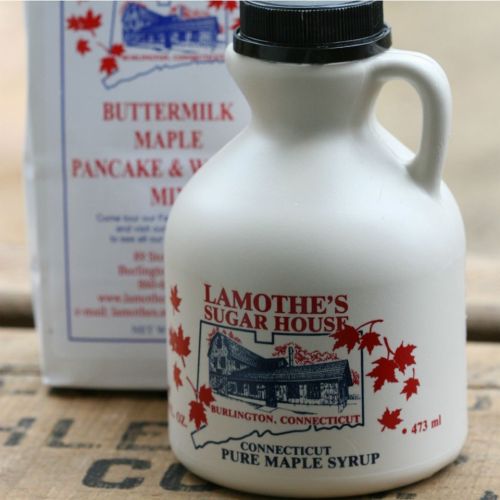 A white jug of pure maple syrup with a red label, next to a box of buttermilk pancake and waffle mix.