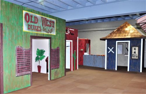 Interior of a themed Old West saloon with colorful wooden facades and a rustic atmosphere.