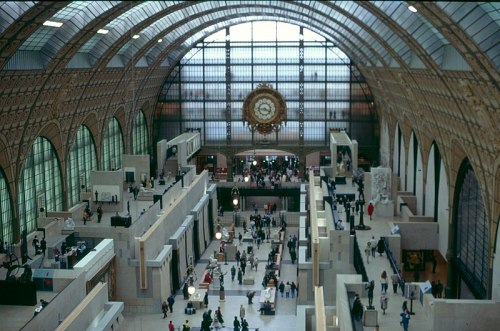 Interior view of the Musée d'Orsay, showcasing its grand architecture and visitors exploring the exhibits.