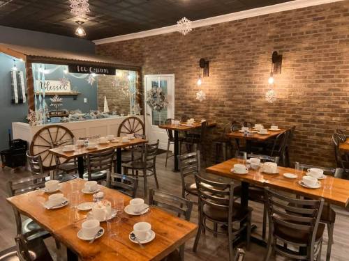 Cozy restaurant interior with wooden tables, chairs, and a dessert display, decorated with snowflakes.