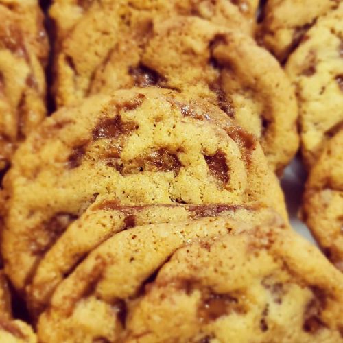 Close-up of freshly baked cookies with a golden-brown color and a slightly glossy surface.