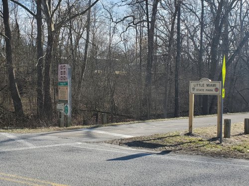 Entrance to Little Miami State Park, featuring signs and a wooded area in the background.
