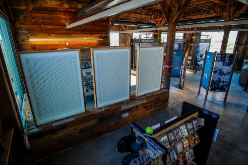 Interior view of a rustic space featuring large framed texts and informational displays, with wooden beams and a modern layout.