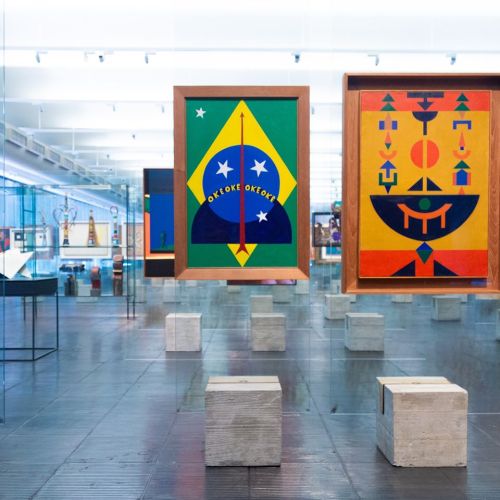 Colorful abstract artworks displayed in a modern gallery with reflective surfaces and minimalist pedestals.