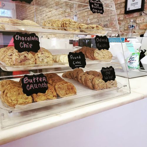 Display case filled with various cookies and pound cake, labeled with chalkboard signs.