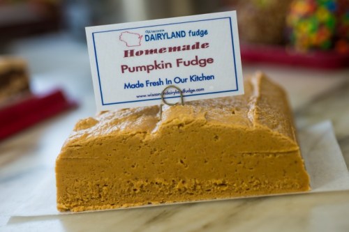 A block of homemade pumpkin fudge with a sign that reads "Wisconsin Dairyland Fudge" on a marble surface.