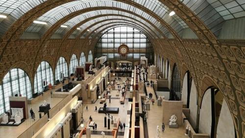 Interior view of the Musée d'Orsay, showcasing its grand architecture and visitors exploring the exhibits.
