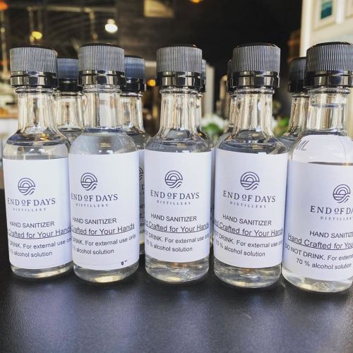 Five bottles of hand sanitizer labeled "End of Days Distillery," with instructions not to drink.