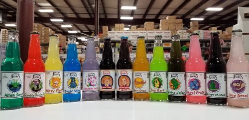 A colorful display of various novelty soda bottles arranged in a row, each with unique labels and flavors.