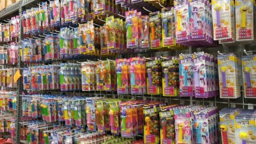 A colorful display of various PEZ dispensers arranged in packages on a store shelf.