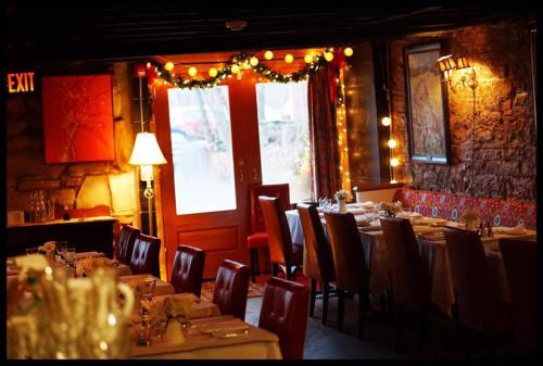 Cozy restaurant interior with festive lighting, decorated tables, and a warm ambiance.