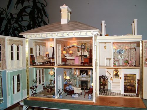 A detailed dollhouse interior showcasing multiple rooms with furniture, decor, and miniature accessories.