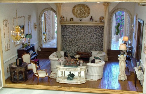 A detailed miniature living room with elegant furniture, a stone fireplace, and decorative accents.