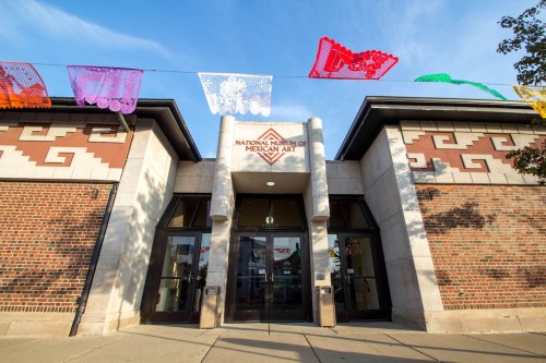 Entrance of the National Museum of Mexican Art, adorned with colorful papel picado banners.
