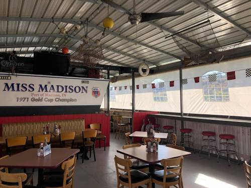 Interior of a casual dining space with tables, a bar, and decor featuring "Miss Madison" and racing memorabilia.