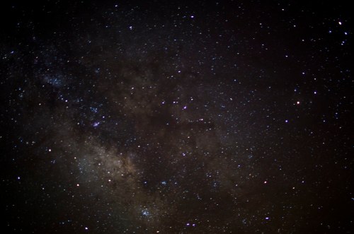 A starry night sky filled with countless stars and a hint of the Milky Way galaxy.