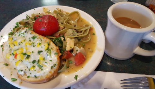 A plate with cheesy corn toast, pasta with vegetables, a tomato, and a cup of coffee on the side.