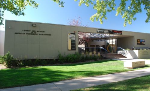 Exterior view of the American Numismatic Association's Library and Museum, featuring a modern building and green landscaping.