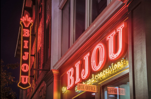 Neon signs for "Bijou" theater and box office, glowing brightly against a night sky.