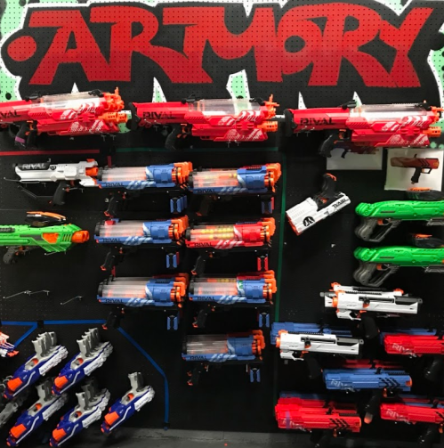 A wall display of various toy blasters in bright colors, labeled "Armory" at the top.