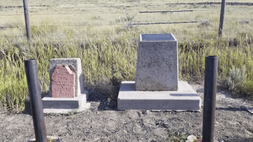 Two historical markers stand side by side in a grassy area, commemorating the Oregon Trail in Wyoming, 1919.
