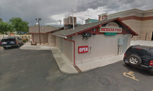 A restaurant building with a sign reading "Peter Prady's Mexican Food" and an "Open" sign, parked cars nearby.